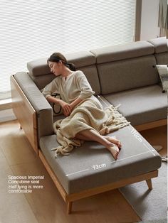 a woman sitting on top of a couch next to a window