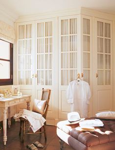 a bathroom with a chair, sink and robe hanging on the door way in front of it