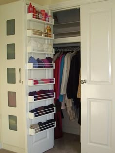 an open closet with clothes and shoes on the shelves in front of it's doors