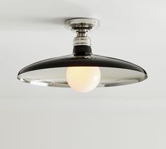 a black and white ceiling light with a round glass shade on it's side