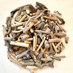 a pile of driftwood sitting on top of a white table next to a knife