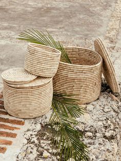 three woven baskets sitting on top of a rock