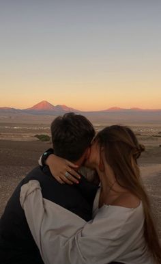 a man and woman kissing in the desert