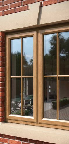 an open window on the side of a brick building with glass panes and wood trim