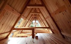 the inside of a wooden building with wood floors and beams on each side of the room