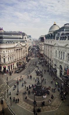 an aerial view of a city square with people walking around