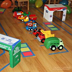 toy trucks and cars are lined up on the floor in a playroom with toys