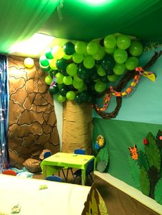 a room filled with balloons and decorations on the walls, including a tree in the center