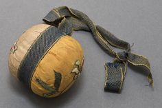 an old cloth ball with blue and yellow designs on it sitting on a gray surface