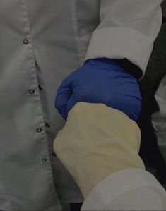 two people in white coats and blue gloves