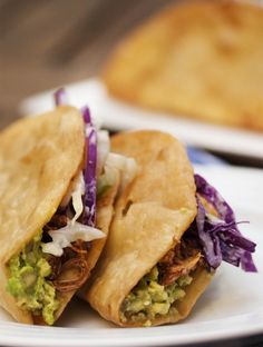 two burritos are sitting on a white plate