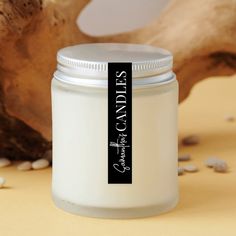 a white jar sitting on top of a table next to a wooden branch and nuts