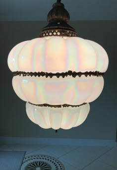 a light fixture hanging from the ceiling in a room with tile flooring and walls