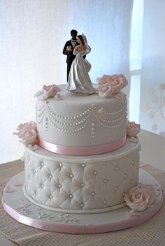 a wedding cake with a bride and groom on top