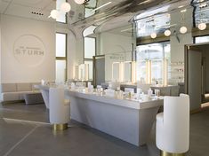 the inside of a salon with mirrors and stools in front of it's counter