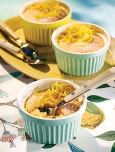 two bowls filled with food sitting on top of a table next to spoons and utensils