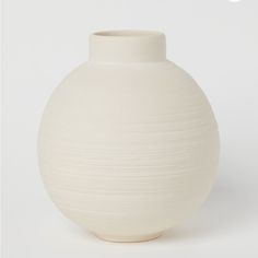 a white vase sitting on top of a table