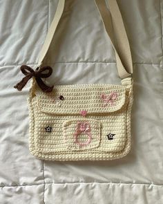 a crocheted purse with a bow on the front and two small buttons at the bottom