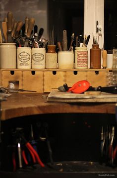 an assortment of kitchen utensils are sitting on a table in front of a mirror