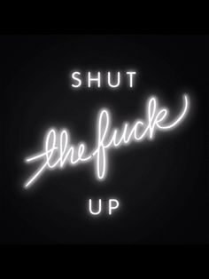 a neon sign that says shut the puck up in white lettering on a black background