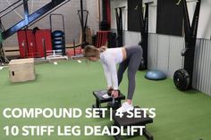 a woman standing on top of a bench in a gym