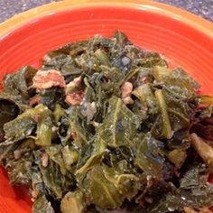 an orange plate topped with greens and meat