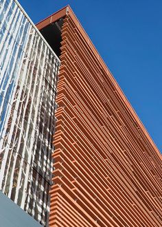 the side of a tall brick building with a clock on it's front corner