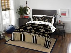 a new orleans saints bed in a room with wood floors and white walls, black and gold comforter set