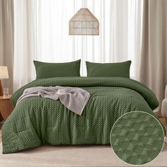 a bed with green bedspread and pillows