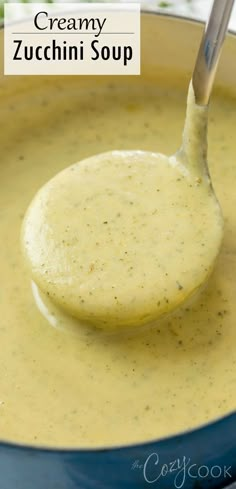 a spoon full of creamy zucchini soup in a blue pot with the title above it