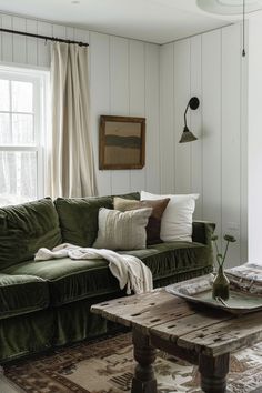 a living room with green velvet couches and rugs