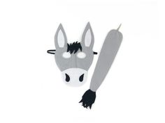 a horse mask with black manes on it's head and nose, sitting next to a white background