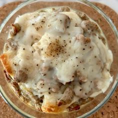 a glass bowl filled with food on top of a cork board