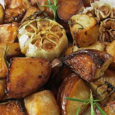 roasted potatoes and onions on a plate with rosemary garnish, ready to be eaten