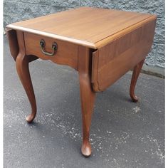 a small wooden table with two drawers on one side and an open drawer on the other