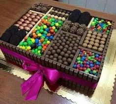 a box filled with lots of different types of candies and chocolates on top of a table