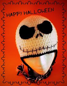 a crocheted skull wearing a white knitted hat with black eyes on an orange background