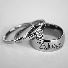 two harry potter wedding rings with their names engraved on the side and one has a hogwarts symbol