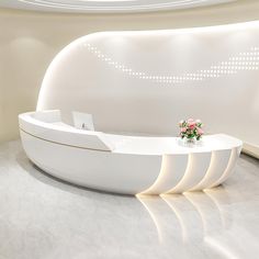 a white reception table with flowers on it in front of a circular wall and ceiling