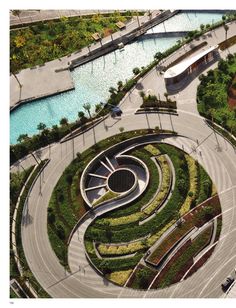 an aerial view of a circular garden with trees and plants in the center, surrounded by water