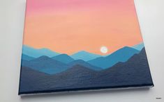 a painting with mountains painted on it and the sun setting in the sky behind them