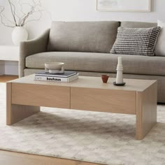 a coffee table sitting on top of a rug next to a couch