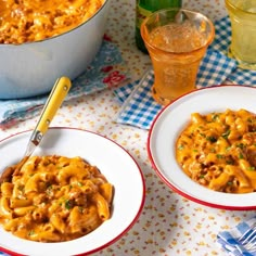 two bowls filled with macaroni and cheese on top of a checkered table cloth