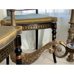 an ornately decorated chair and side table in gold, black and white colors with a blue upholstered cushion