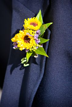 a boutonniere with yellow and purple flowers attached to it's lapel