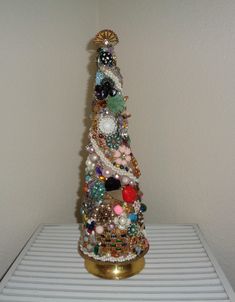 a small christmas tree made out of beads and other items on top of a shelf