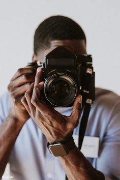 a man holding up a camera to take a photo with it's reflection in the lens