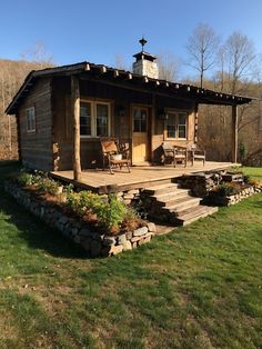 a small wooden cabin sitting on top of a lush green field