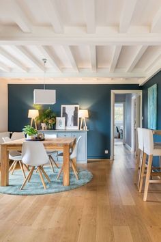 a dining room with blue walls and wooden floors