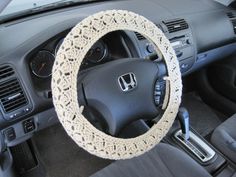 the steering wheel cover is crocheted and sits on top of the car's dashboard